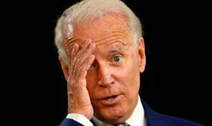 President Biden with hand on his face.