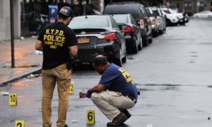 Two New York crime scene police officers inspecting a crime scene in the road.