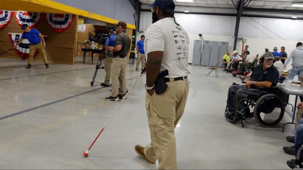 Vision-impaired competitive shooter taking his position at the firing line.
