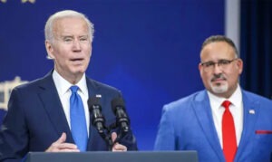 Photo of President Joe Biden speaking at a podium with Secretary of Education Miguel Cardona to his right. The Biden Administration is now attacking youth hunting programs