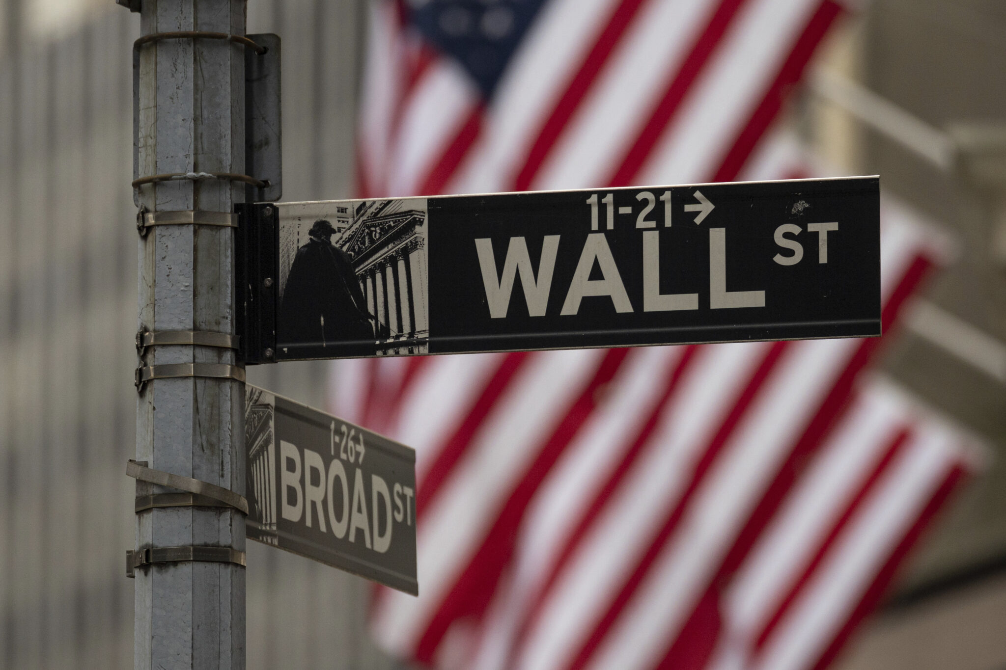 A photo of the Wall Street sign hangs near to the New York Stock Exchange - Banking / Financial Discrimination