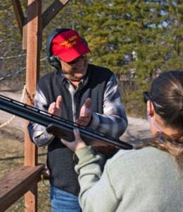 Waukesha Gun Club First Shots instructor claps for a student after breaking a clay.